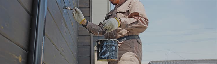 外壁塗装を刷毛で塗装作業を行っている